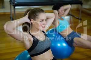 Fit women exercising on fitness ball