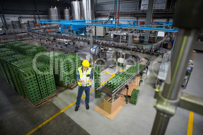 Male factory worker maintaining record on clipboard