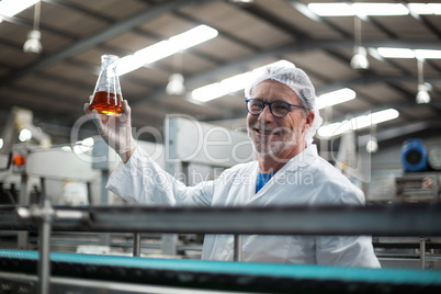 Factory engineers holding a sample of drink