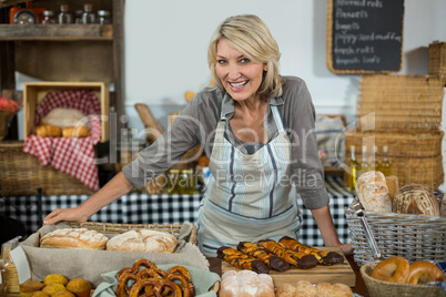 Portrait of female staff standing at counter in bake shop
