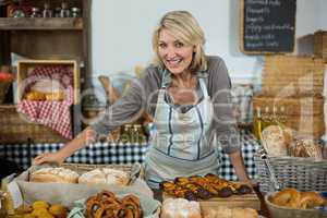 Portrait of female staff standing at counter in bake shop