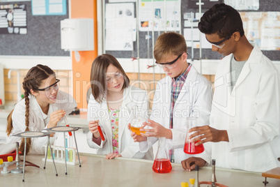 Attentive school kids doing a chemical experiment in laboratory