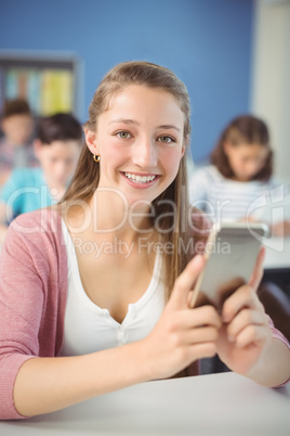 Student holding mobile phone in classroom