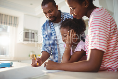 Parents assisting daughter with homework