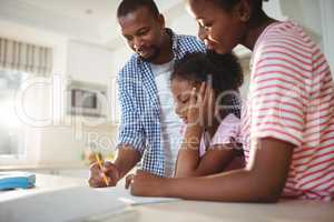 Parents assisting daughter with homework