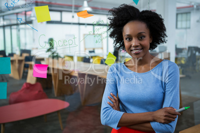 Female graphic designer standing with hands crossed in creative office