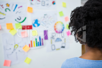 Female graphic designer looking at white board