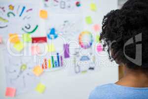 Female graphic designer looking at white board
