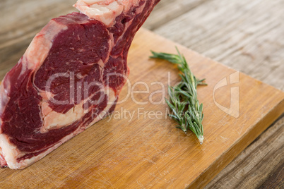 Rib chop steak and rosemary herb on wooden board against wooden background