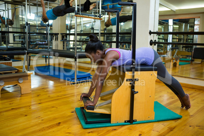 Determined woman exercising on wunda chair
