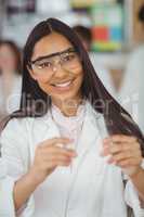 School girl experimenting with piece of glass in laboratory at school