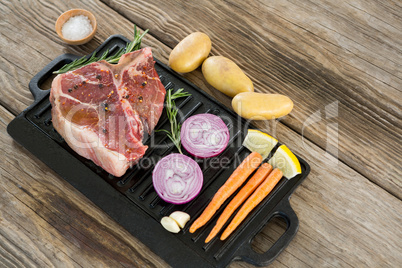 Sirloin chop and ingredients in black box against wooden background