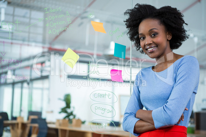 Female graphic designer standing with hands crossed in creative office