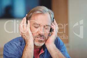 Male graphic designer listening music on headphones