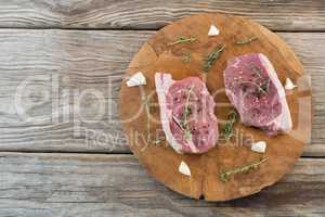 Sirloin steak, garlic and herb on wooden tray against wooden background