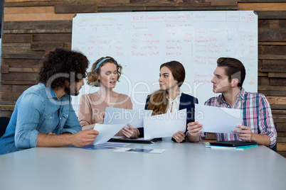 Business executives discussing over document in meeting