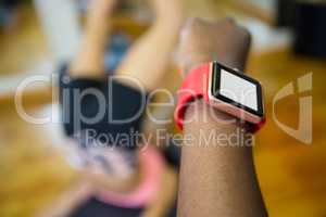 Womans hand using smart watch while workout in fitness studio