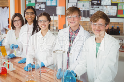 Portrait of school kids doing a chemical experiment in laboratory