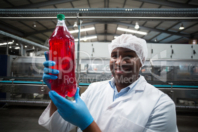 Factory engineer holding a bottle of juice