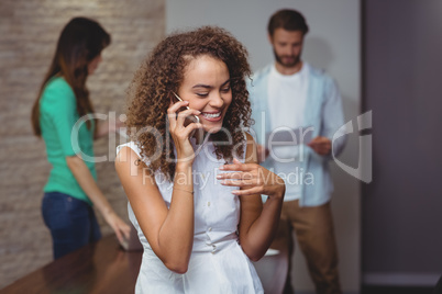 Female executive talking on mobile phone in office