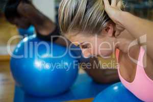 Fit woman performing pilate on exercise ball in fitness studio
