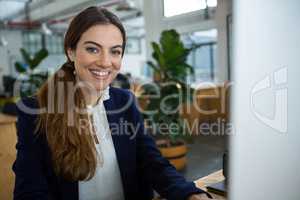 Smiling female executive working on computer