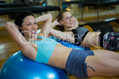 Portrait of happy women exercising on fitness ball