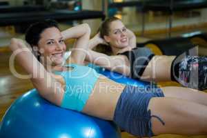 Portrait of happy women exercising on fitness ball