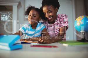 Mother assisting daughter with homework