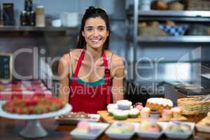 Portrait of female staff standing at counter in bake shop