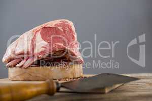 Beef ribs rack and knife on wooden tray against wooden background