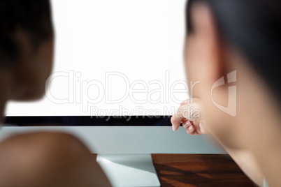 Female graphic designer pointing to desktop pc