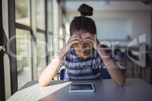 Worried schoolgirl sitting in classroom