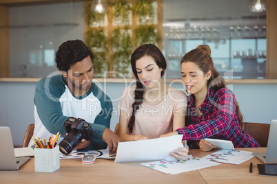 Graphic designers sitting at table and interacting Graphic designers sitting at table and interacting