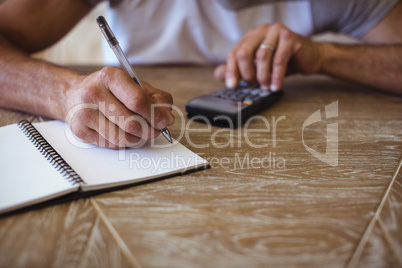 Man using calculator to calculate expenses