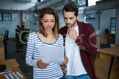 Man and woman discussing over document