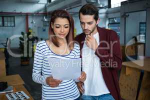 Man and woman discussing over document