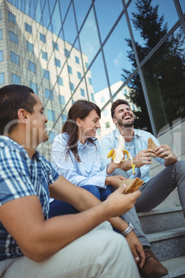 Executives having breakfast outside office building