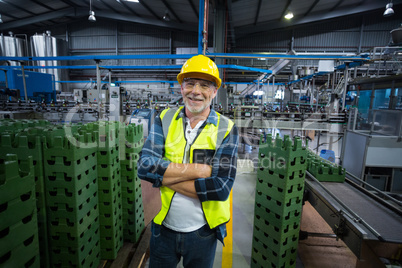 Portrait of male factory worker standing with arms crossed