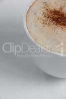 Close-up of white coffee cup with creamy froth