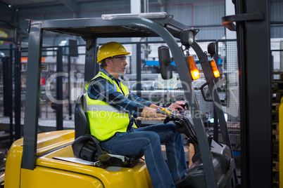 Factory worker driving forklift