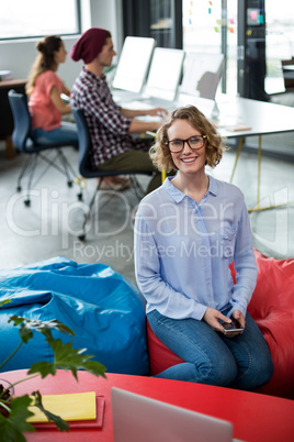 Smiling female business executive sitting in office