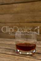 Glass of whisky on wooden table