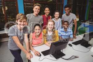 Portrait of smiling students studying in computer classroom