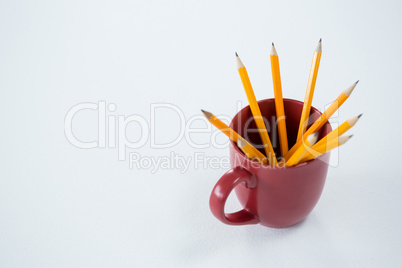 Yellow color pencils kept in mug on white background