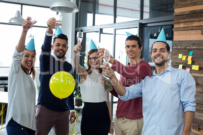 Businesspeople showing glasses of champagne in office