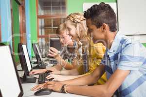 Smiling students studying in computer classroom