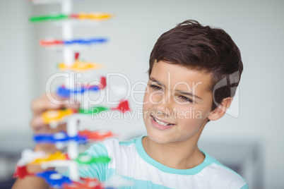 Attentive schoolboy experimenting molecule model in laboratory