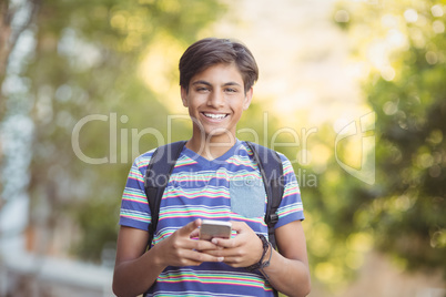 Schoolboy using mobile phone in campus at school