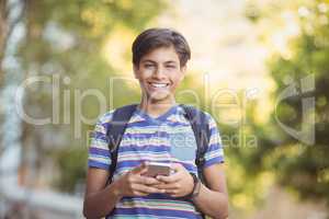 Schoolboy using mobile phone in campus at school